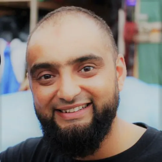 a picture of a different bearded man in a black shirt smiling at the camera